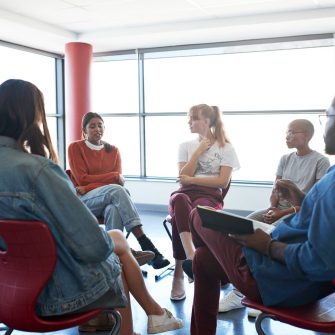 A group of people sitting down in a group treatment session