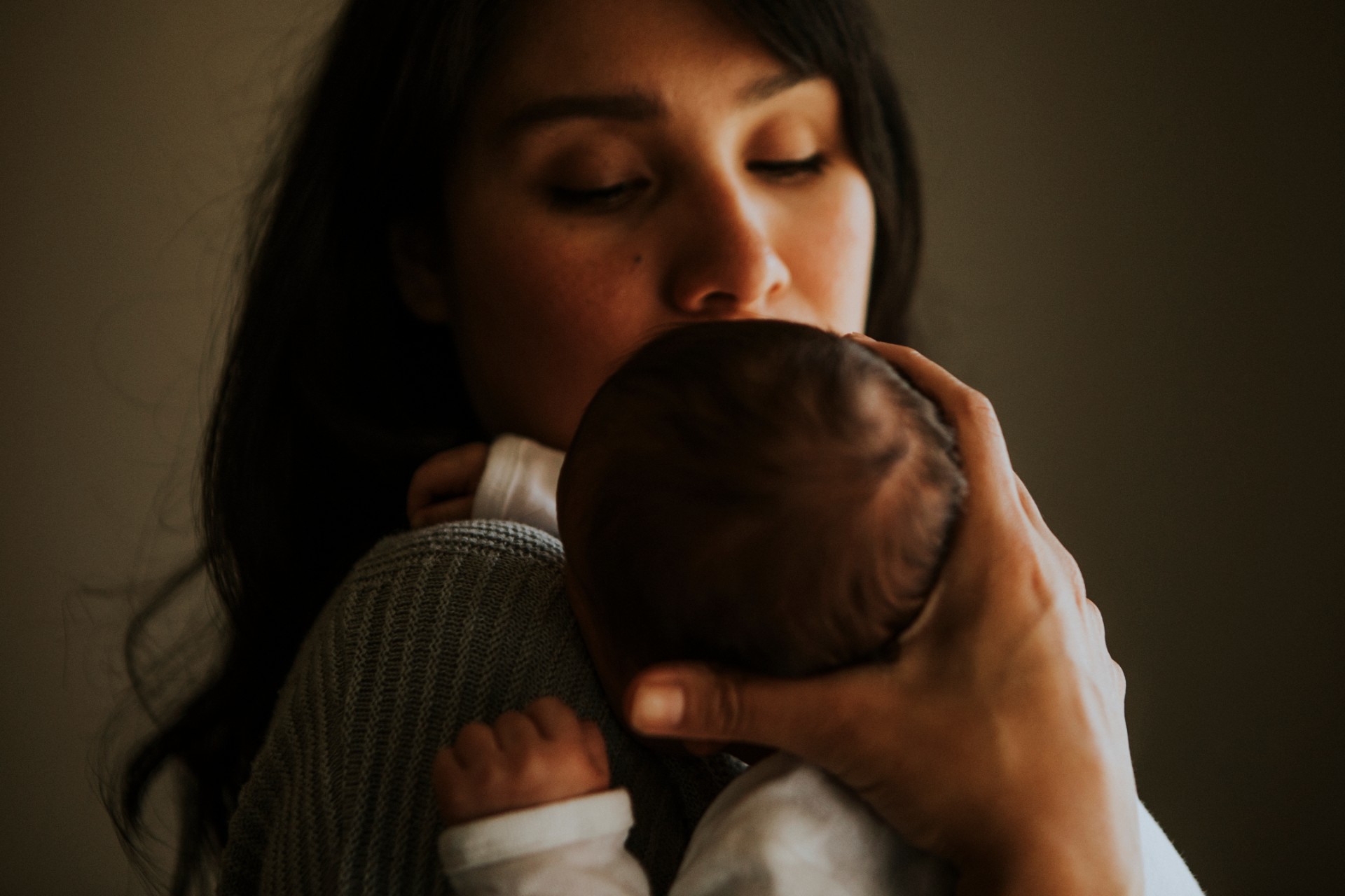 Mother holding her baby indoors