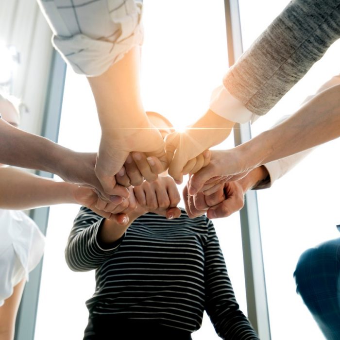 Close up top view of young and freshness energy business people putting their strong hands together. Stack of friendship hands. Unity and successful teamwork concept.