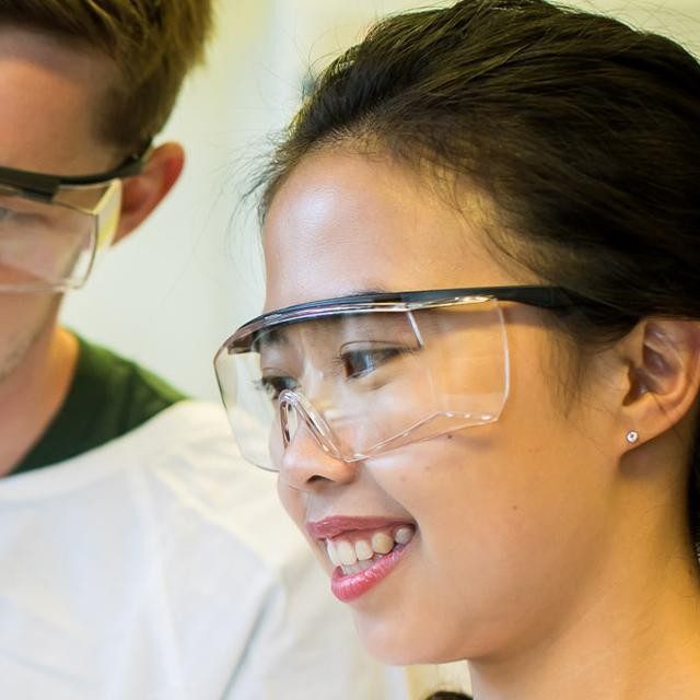 Students in lab looking at tissue culture tube