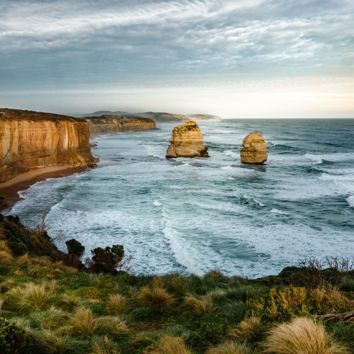 Rock formations on sea under cloudy sky