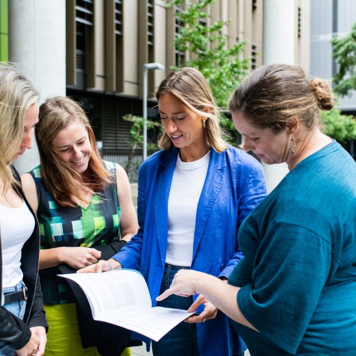 HR staff outside reading brochure 