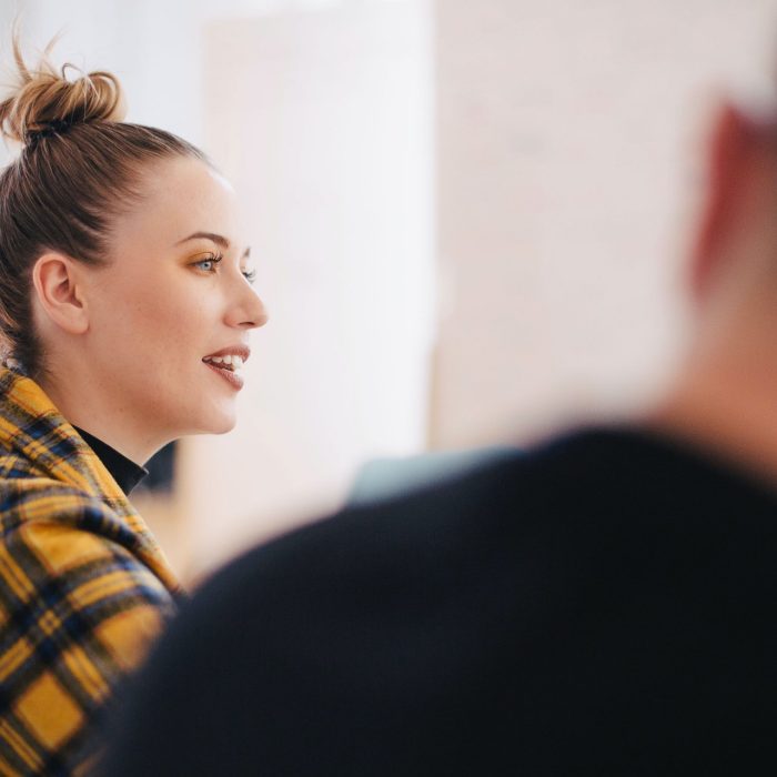 Young woman with hair in a bun wearing yellow and black plaid shirt