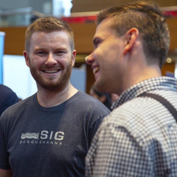 Two young man standing together smiling