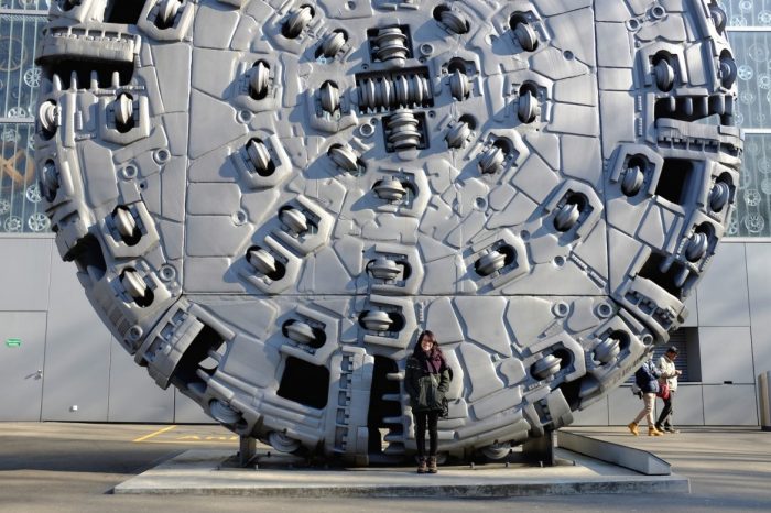 student in front of sculpture