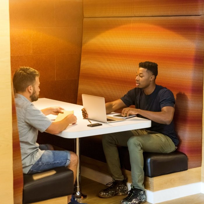 Two men working together in a booth