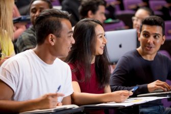 Students with laptops in lecture theatre class