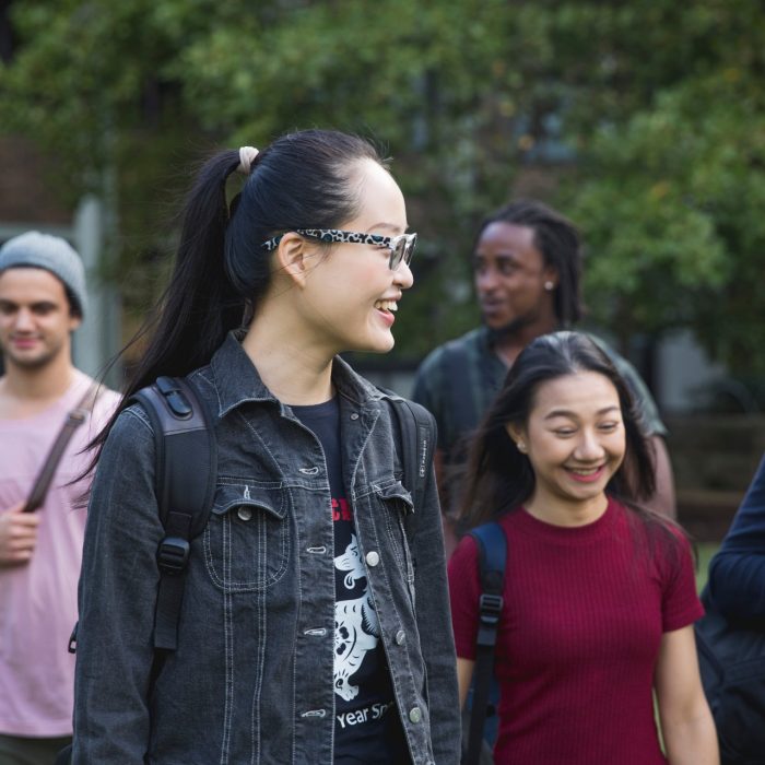 Students walking and talking on campus green