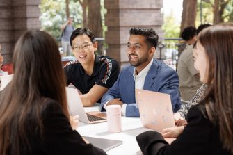 Students sitting table, working together