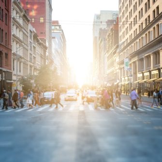 People in New York cross the street at a pedestrian crossing