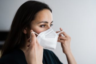 Woman putting on N95 mask