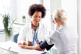 Doctor measure blood pressure mature woman at ambulance