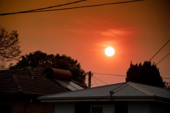 Australian bushfire: smoke from bushfires covers the sky and yellow and red sunset above the roofs looks frightening. Suburb in a smoke haze. Catastrophic fire danger, NSW, Australia