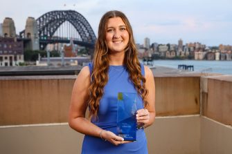 A young woman standing with an award.