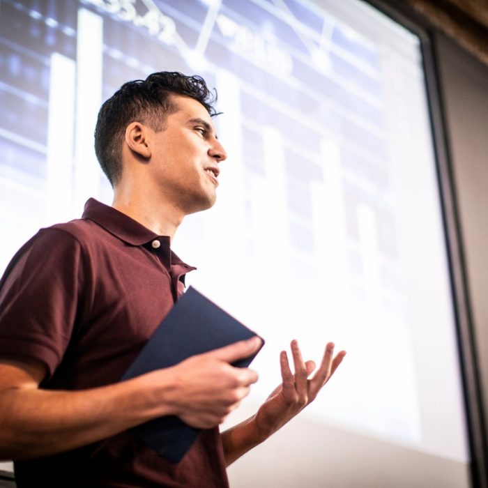 Young professional man giving presentation in modern office space