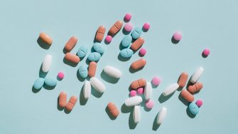 Colourful pills and capsules on a blue background