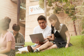 Students on campus looking at a laptop