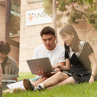 Students on campus looking at a laptop