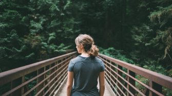 Young woman crossing footbridge