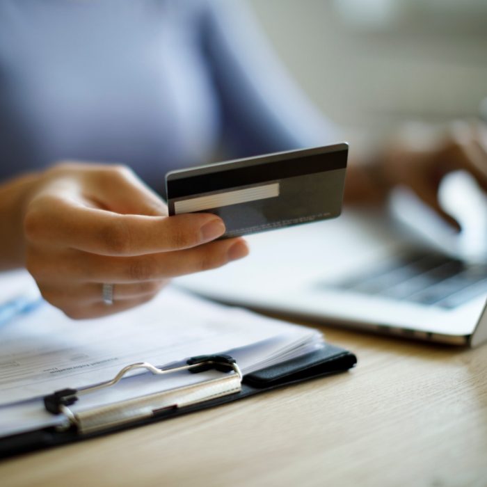 Woman using credit card and laptop to pay bills