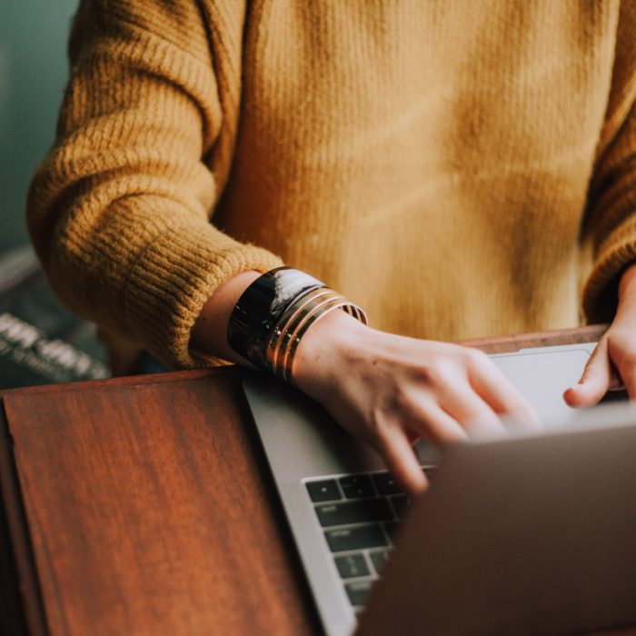 Photo of casual person typing on a Macbook