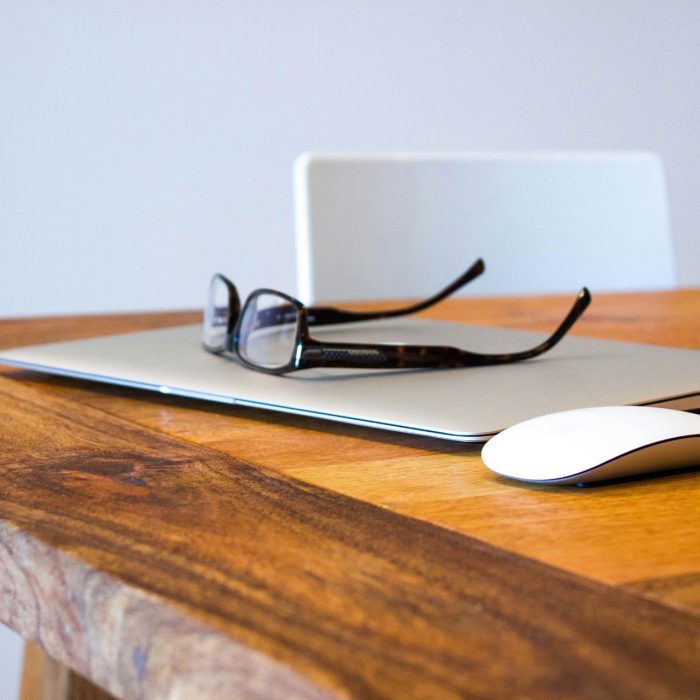 Photo of eyeglasses with laptop and mouse