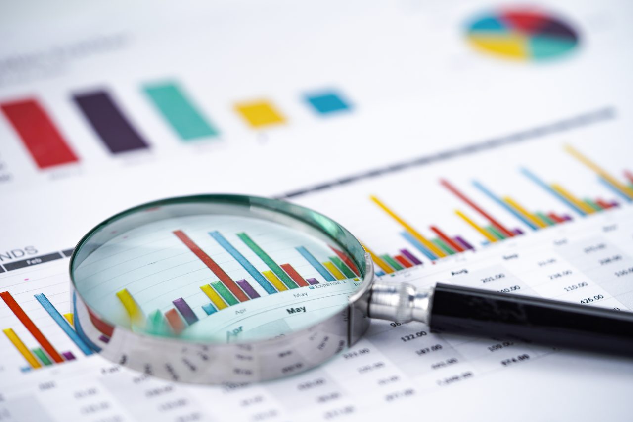 Magnifying glass on charts graphs spreadsheet paper. Financial development, Banking Account, Statistics, Investment Analytic research data economy, Stock exchange trading, Business office company meeting concept.