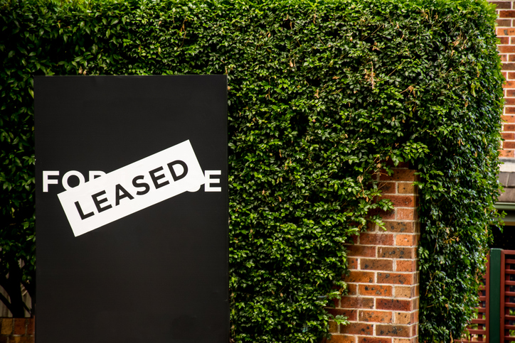 For lease and leased sign on a black display outside of a resedential building