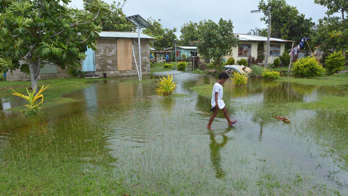 Fijian girl walks across flooded land