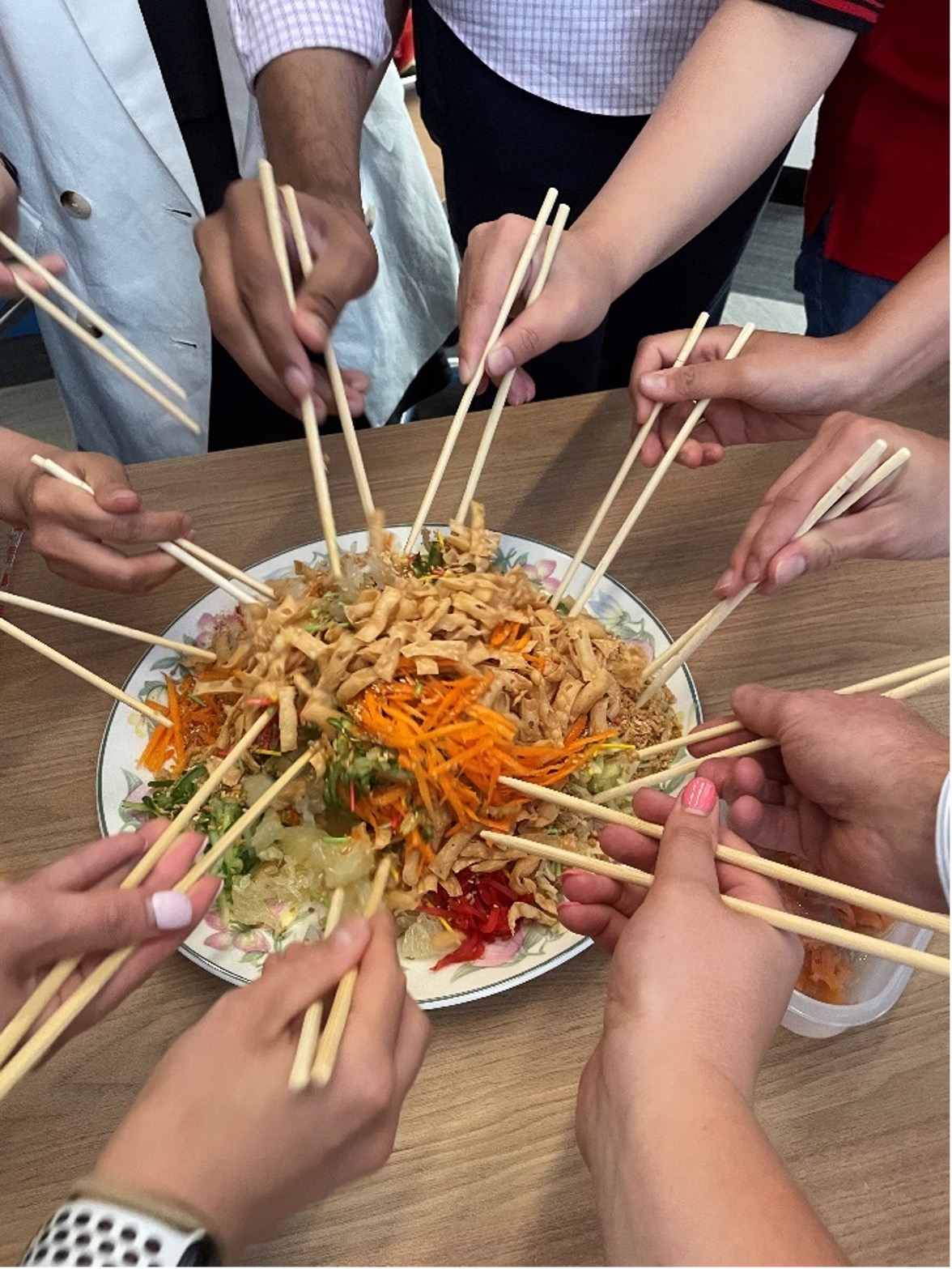 The UNSW Aviation team celebrates Chinese New Year by participating in the tossing of the Prosperity Salad