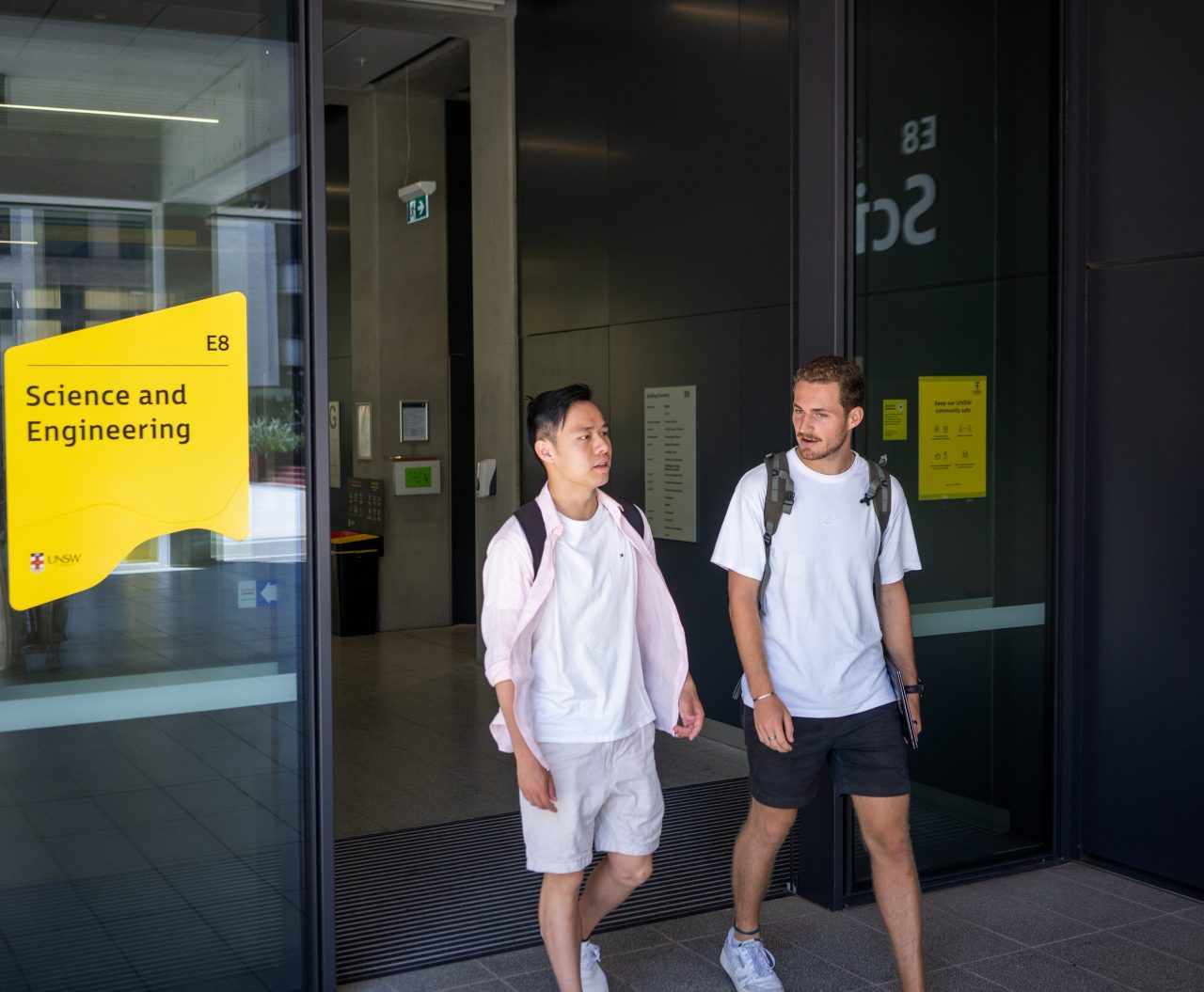 Two students chatting while exiting the Science & Engineering building on UNSW Kensington Campus