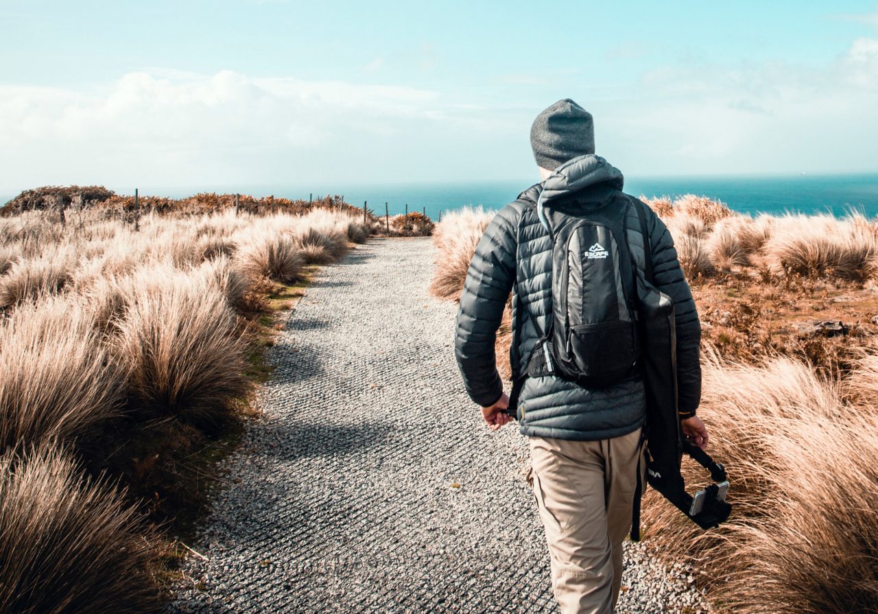 Hiker walking along track through countryside of Tasmania