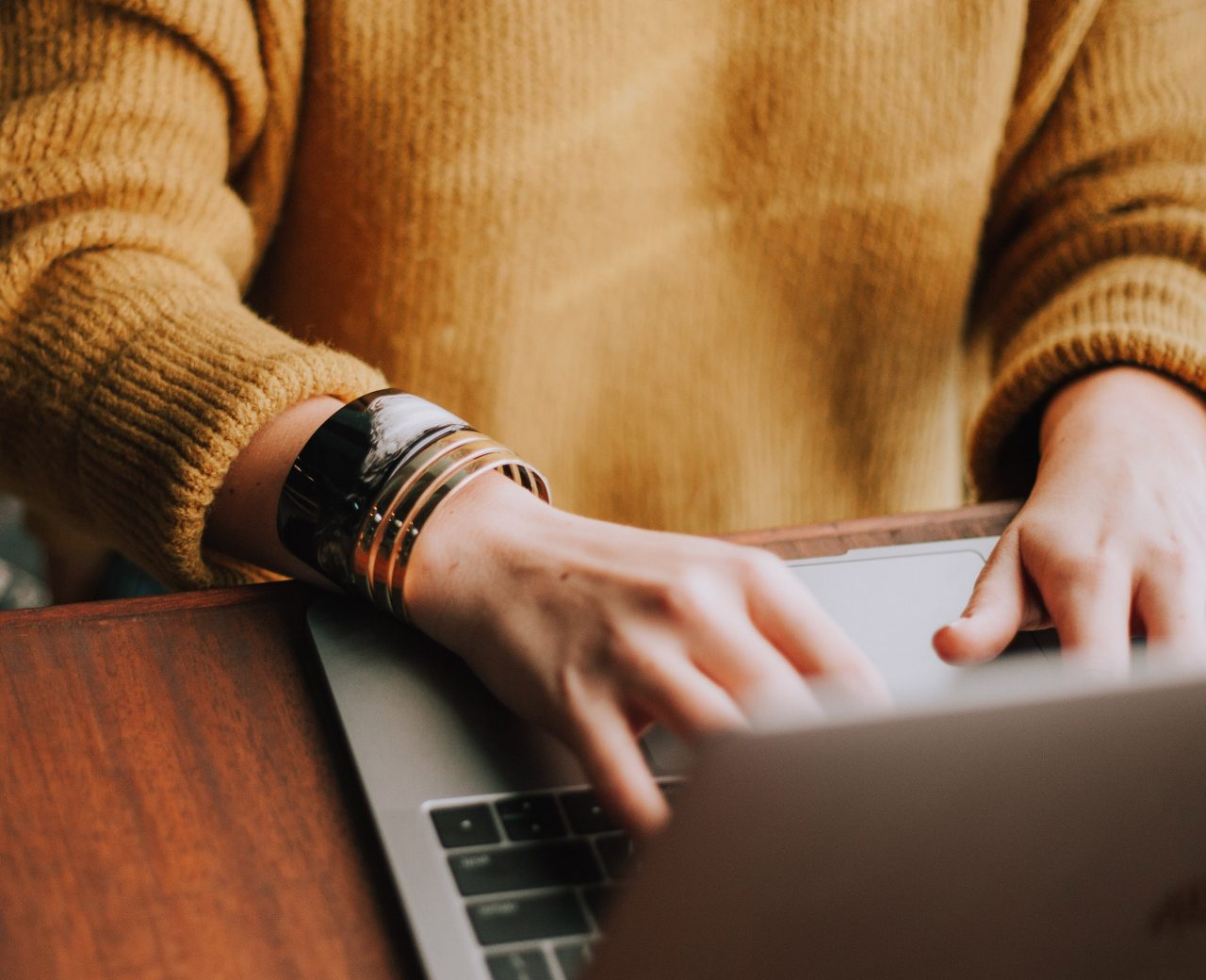 Photo of casual person typing on a Macbook